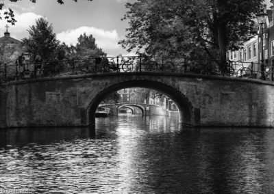 monochrome view of a series of arched bridges in Amsterdam